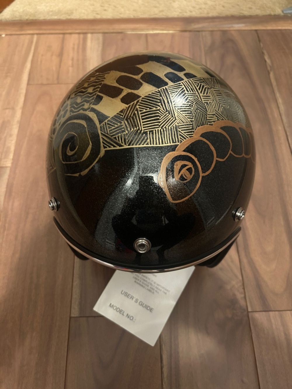 Decorative Black Helmet with Gold Graphic Accents